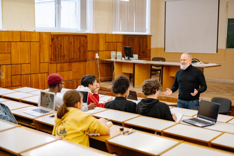 Lärare samtalar med gymnasieelever i en realistisk skolmiljö